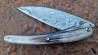 Couteau pliant Toltek lame damas Œil d'Odin et son manche en croûte de zébu de chez Mercorne