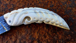 Couteau à friction manche en dent de Phacochère gravée et sa lame damas