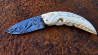 Couteau à friction manche en dent de Phacochère gravée et sa lame damas