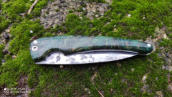 Couteau pliant fermé, avec un manche en racine de buis stabilisée et teintée vert.